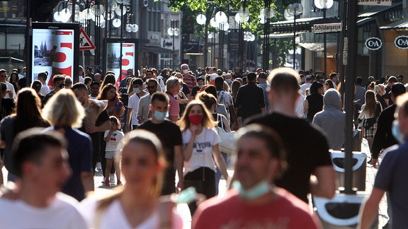 Passanten mit Mund-Nasen-Schutz in gut gefüllter Innenstadt von Köln